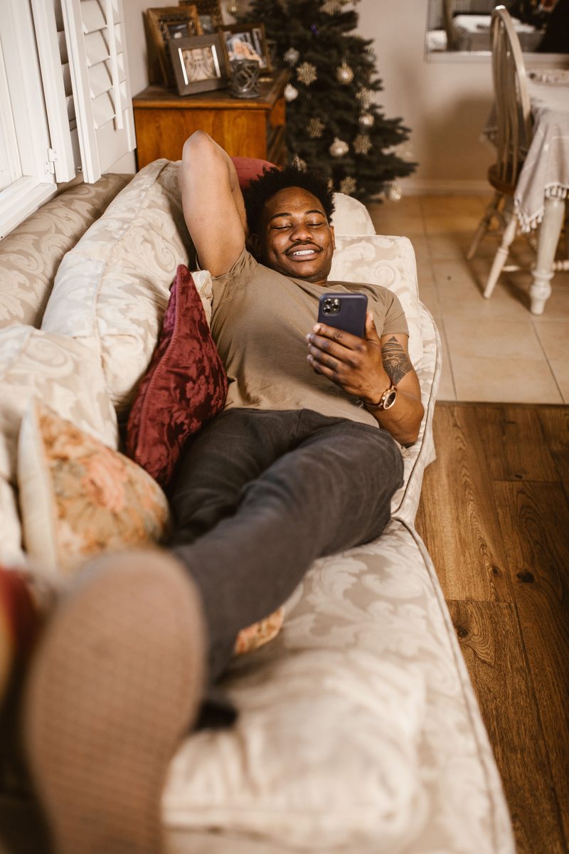 A parent relaxing at home watching a live stream on their phone
